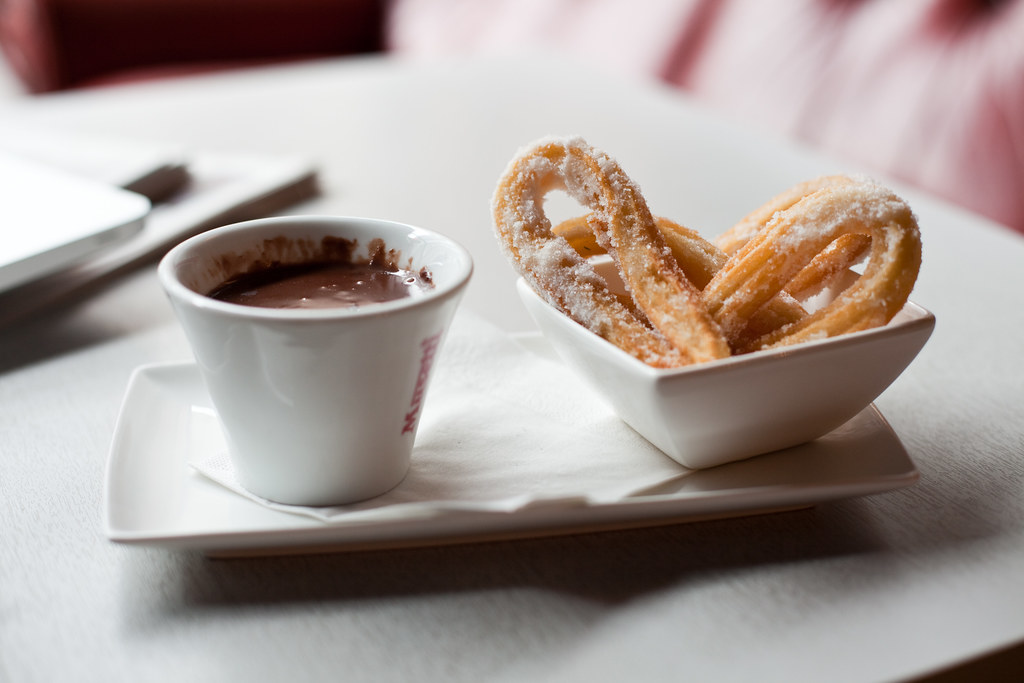 Churros espolvoreados con azúcar, con chocolate para bañar