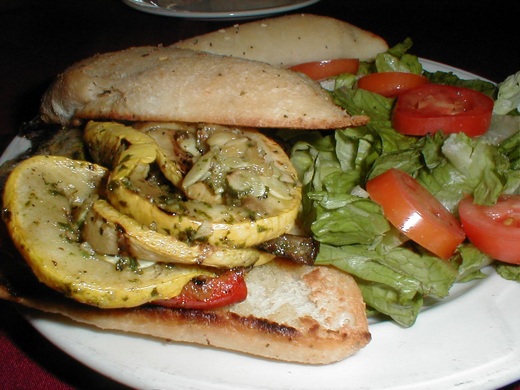 Sándwich abierto con vegetales asados y ensalada